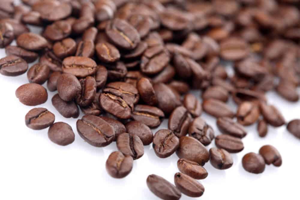 coffee beans on white table top.