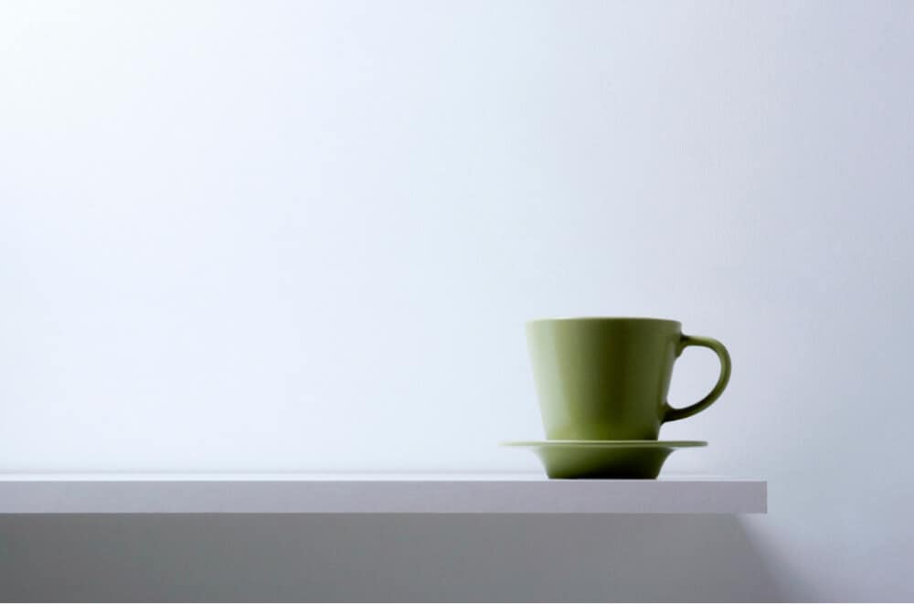 green coffee mug on white table