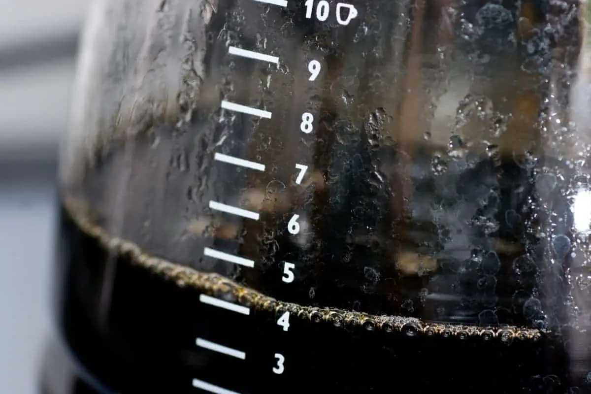 close up of coffee pot containing four cups of coffee