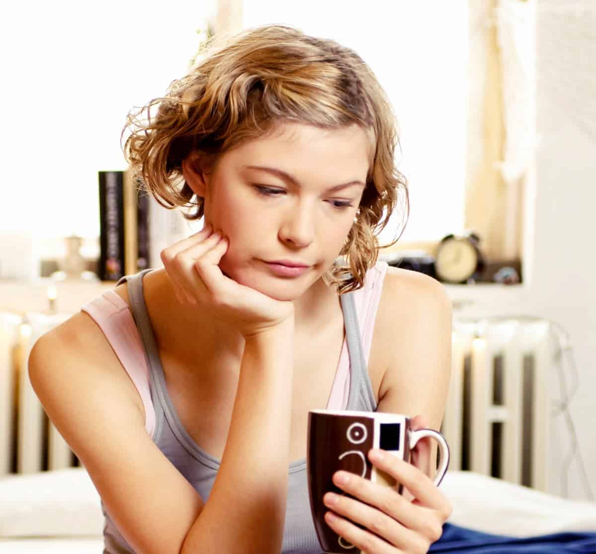 Sad woman drinking coffee.
