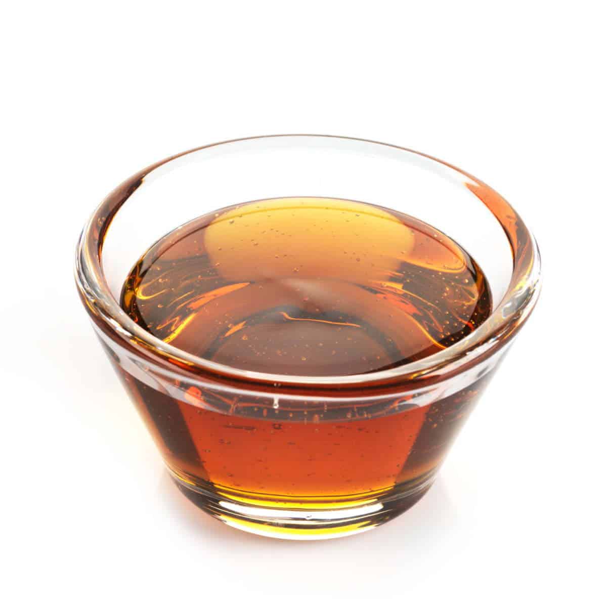 Syrup in glass cup with white background.