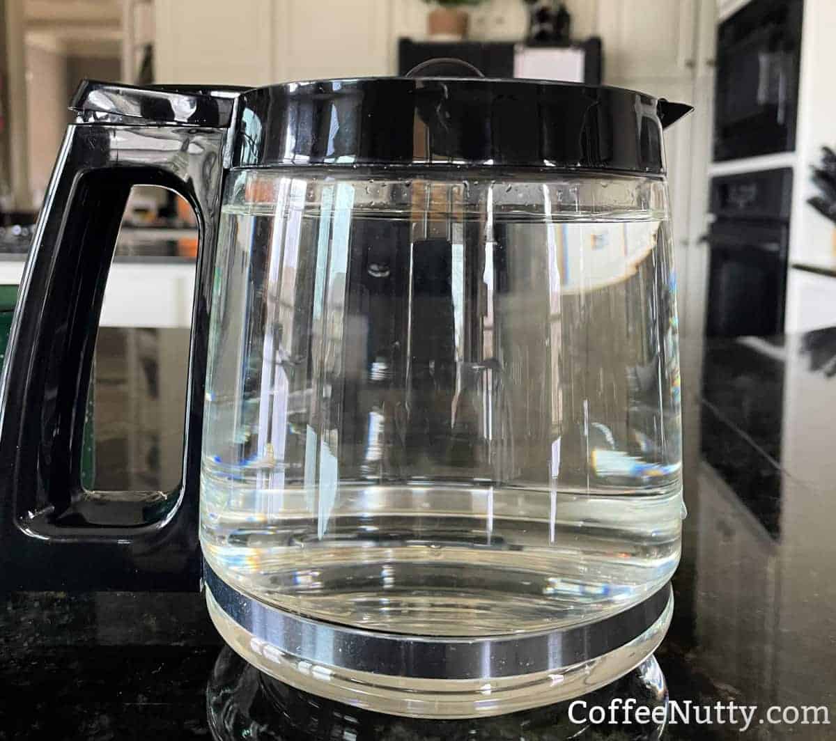 12-cup coffee pot filled with 60 ounces of water sitting on kitchen counter.