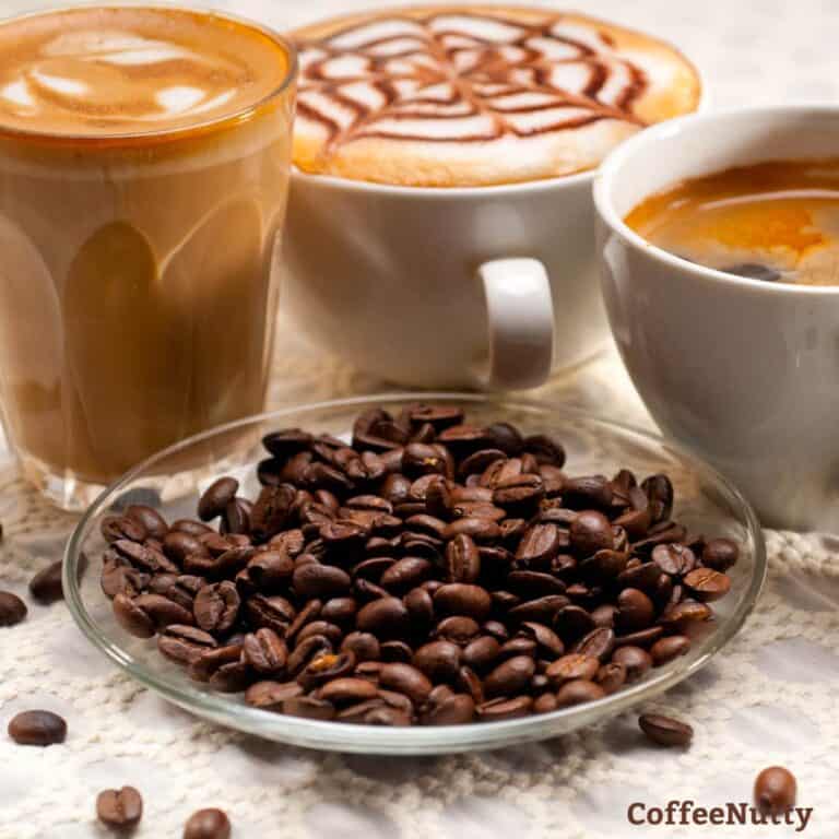 Coffee of various sorts sitting on table in mugs including latte art.