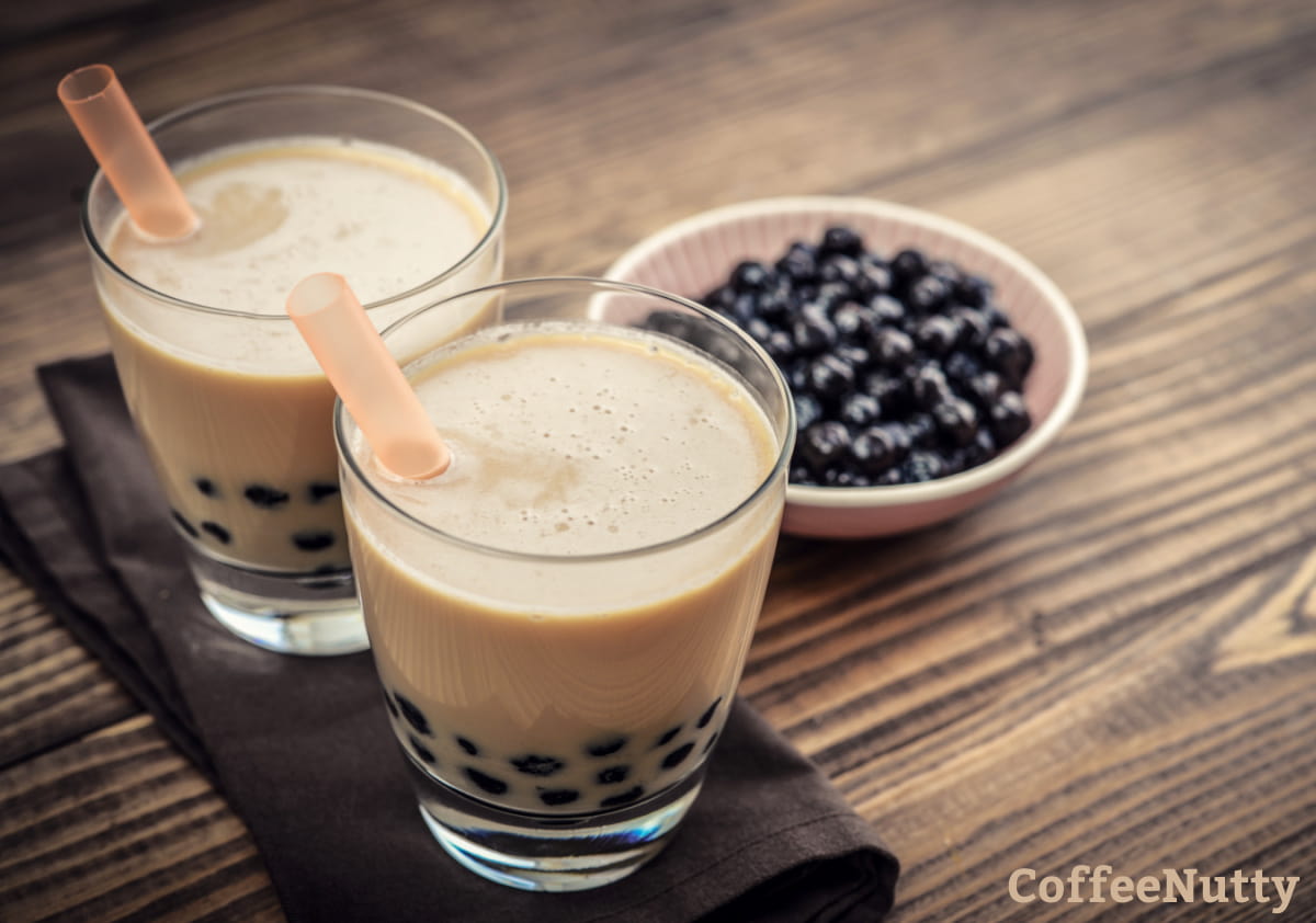 Two glasses of milk bubble tea with tapioca pearls.