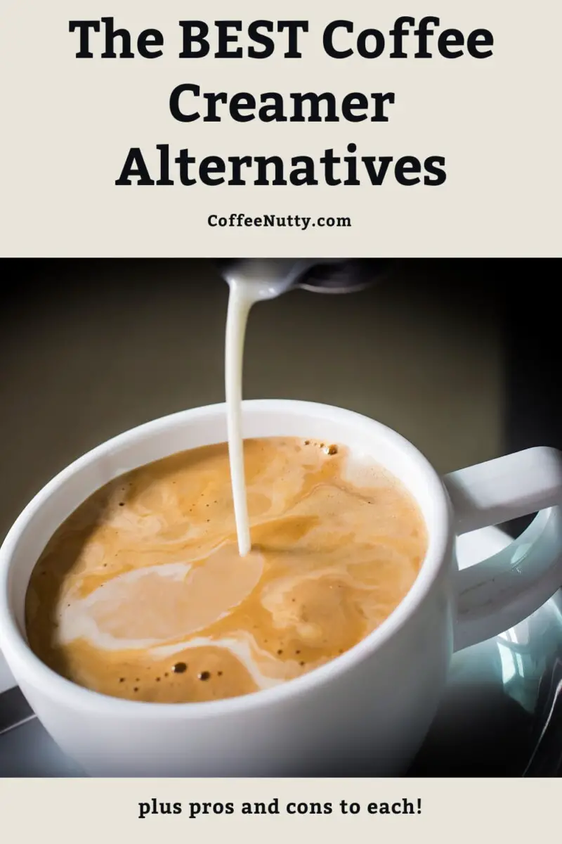 Coffee creamer being poured into mug of coffee.