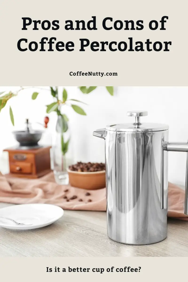 Coffee percolator on counter beside coffee beans and white saucer.
