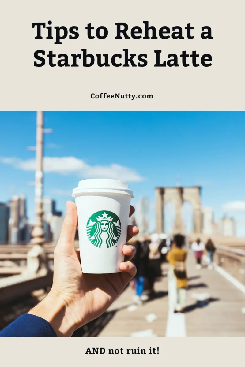 Man holding Starbucks drink in air outside.