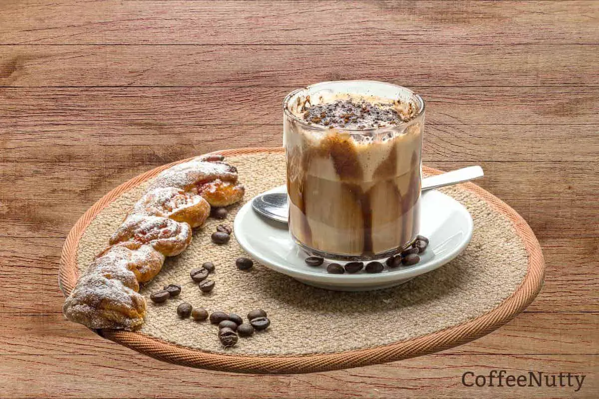 Hot chocolate and coffee mixed in beverage to make a mocha beside a pastry.