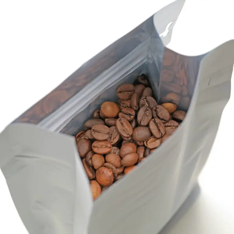 Coffee beans in opened white bag.