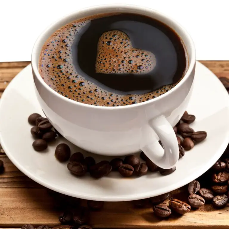 Black coffee in a white mug with heart shaped froth design.