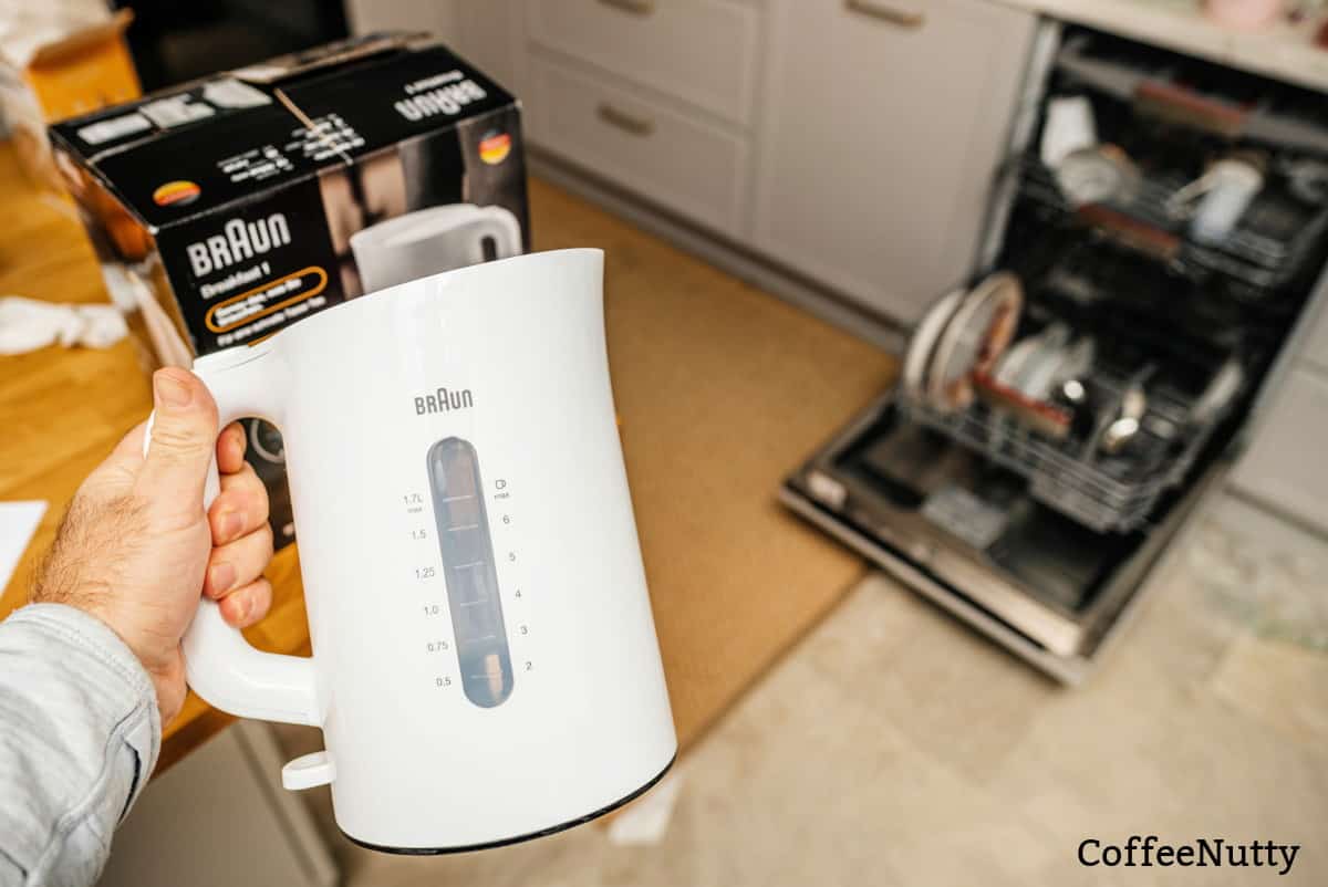 White Braun coffee machine, man preparing to clean in kitchen.