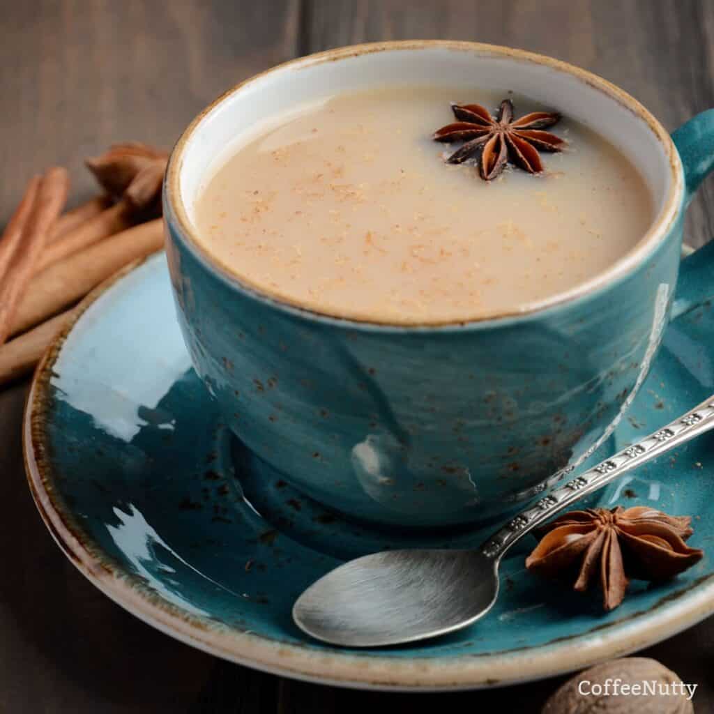 Chai tea with milk in cup sitting on saucer.