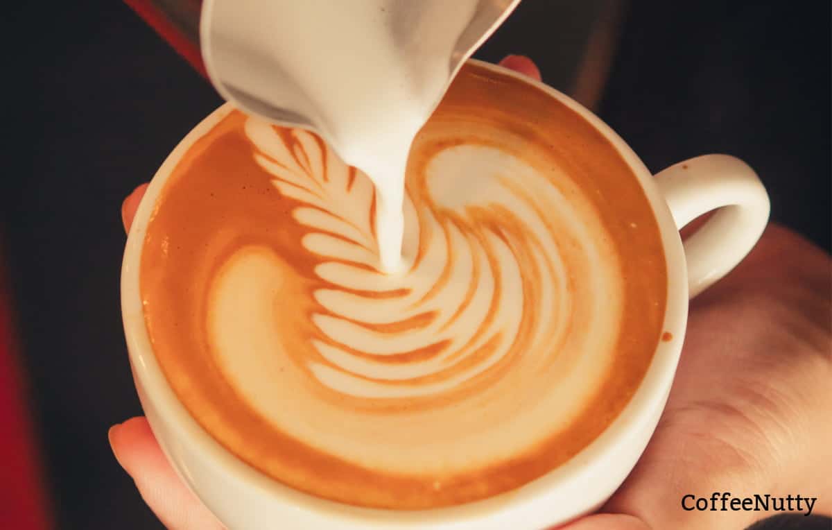 Creating latte art with frothed whole milk.