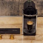 Nespresso coffee machine on counter beside coffee pods.