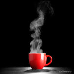 Seaming coffee in red mug with black background.